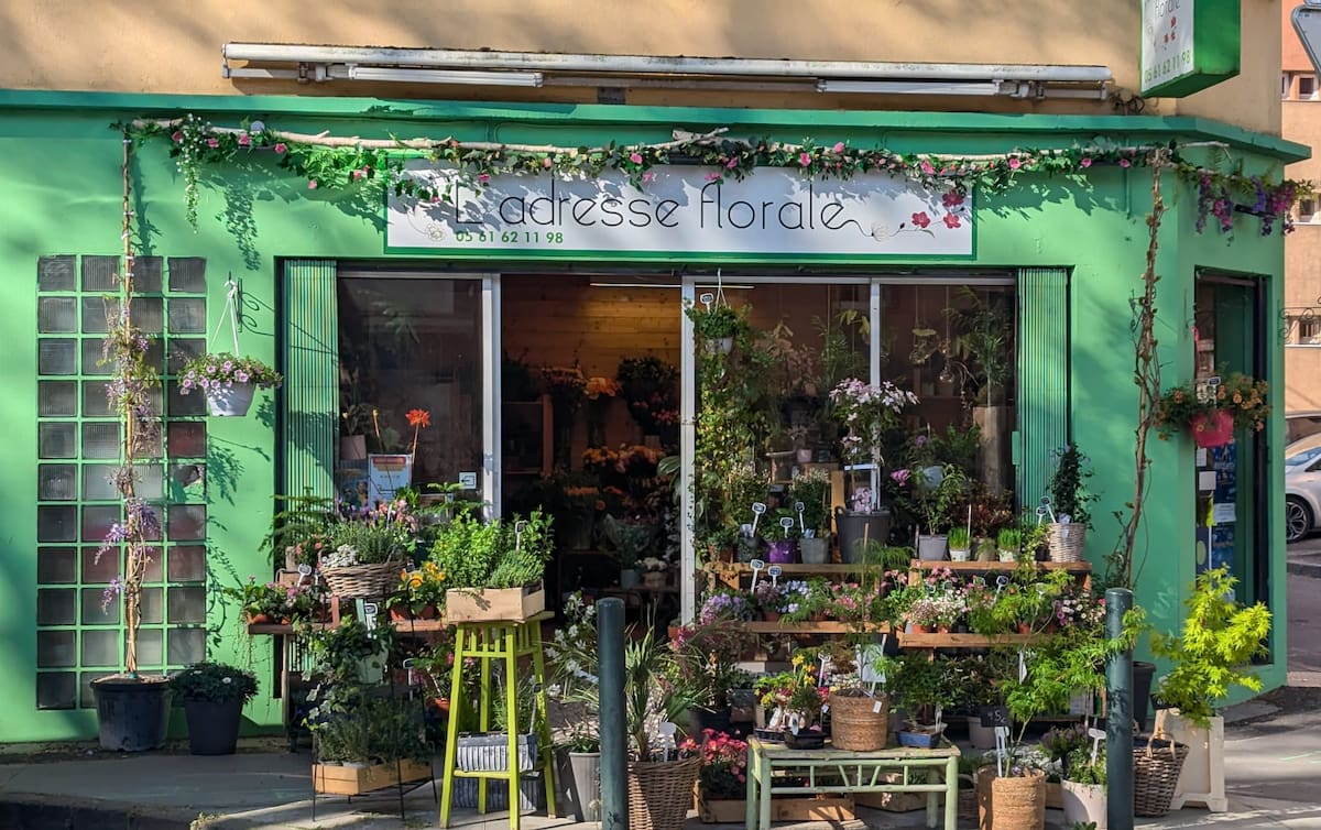 Devanture de L'Adresse Florale, fleuriste aux Sept Deniers, avec plantes et fleurs en vitrine